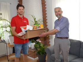 Dennis Kahlenberg, DIE LINKE. Büttelborn, übergibt ein Snack-Paket an Herr Lühder.